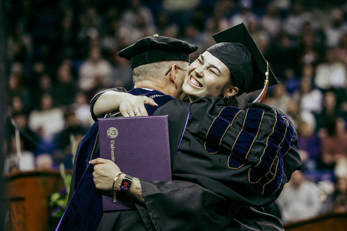 Graduating student hugs President Nook at Commencement