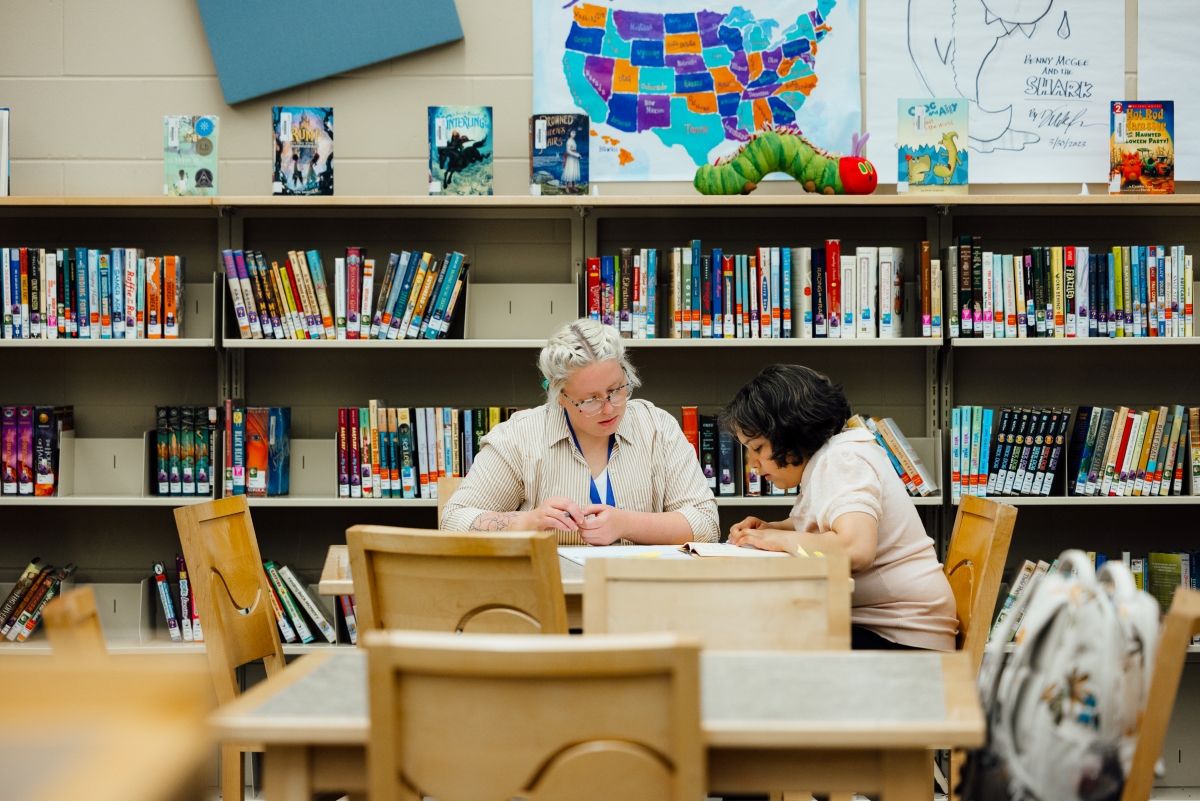 Teacher helping student in classroom