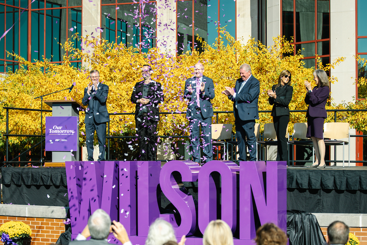 Confetti cannon goes off as giant sign of Wilson is revealed in front of Curris Business Building